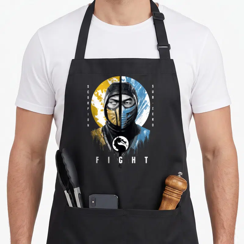 Klassic zero apron - Split ninja face yellow blue circle SCORPION SUB-ZERO FIGHT dragon logo — shown on a black cotton canvas apron against a white background