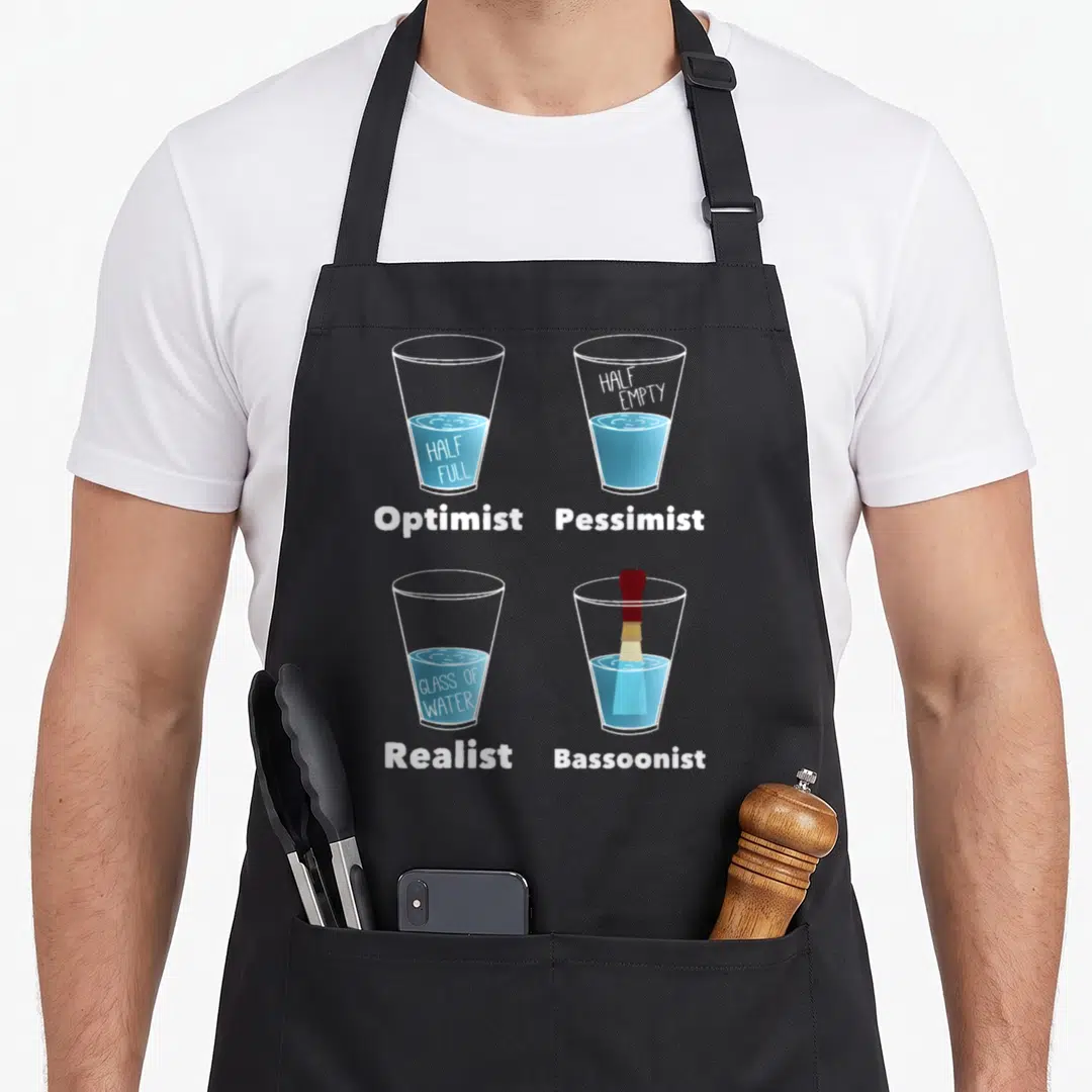 Bassoonist bassoon apron - Four glasses of water labeled Optimist Pessimist Realist Bassoonist with a reed in the last — shown on a black cotton canvas apron against a white background