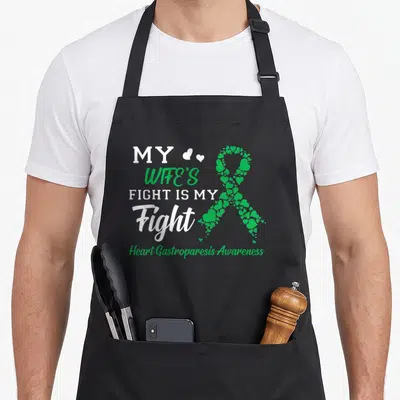 Fight gastroparesis wife apron - My Wife's Fight Is My Fight text next to green heart ribbon — shown on a black cotton canvas apron against a white background