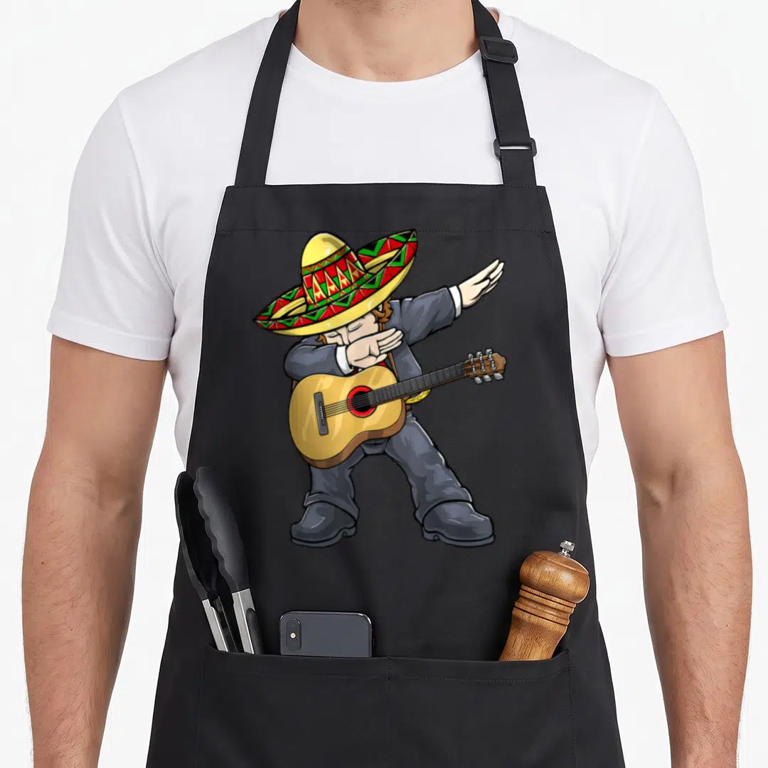 Dabbing mariachi mexican apron - Cartoon mariachi in grey suit and colorful sombrero dabbing while holding an acoustic — shown on a black cotton canvas apron against a white background