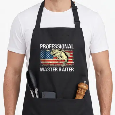 Master professional apron - Bass fish over distressed American flag with Professional Master Baiter text — shown on a black cotton canvas apron against a white background