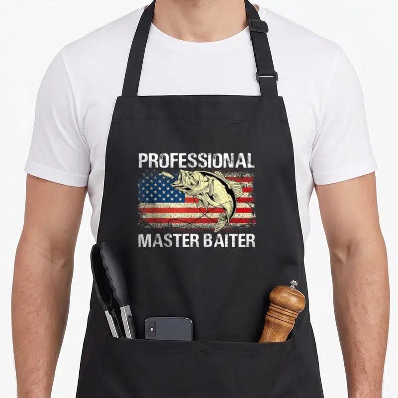 Master professional apron - Bass fish over distressed American flag with Professional Master Baiter text — shown on a black cotton canvas apron against a white background