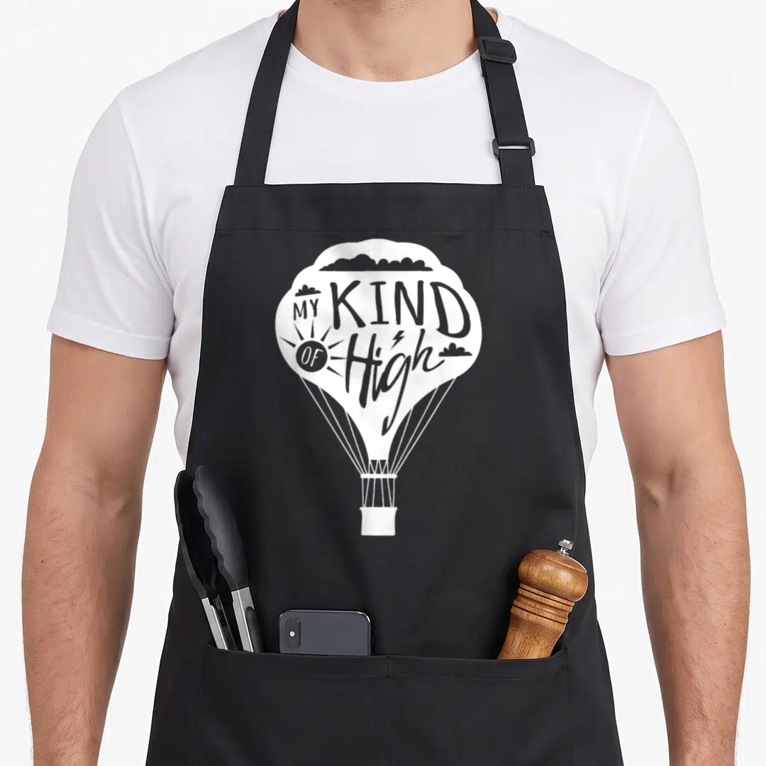 Kind balloon apron - White hot air balloon with MY KIND OF High text and lightning bolt inside the H — shown on a black cotton canvas apron against a white background
