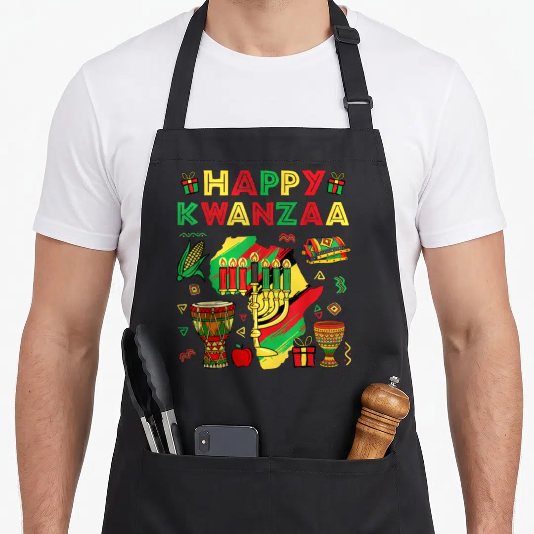 Kinara african american aprons - Cartoon Africa map with kinara, drum, corn, and HAPPY KWANZAA text in red yellow green — shown on a black cotton canvas apron against a white background
