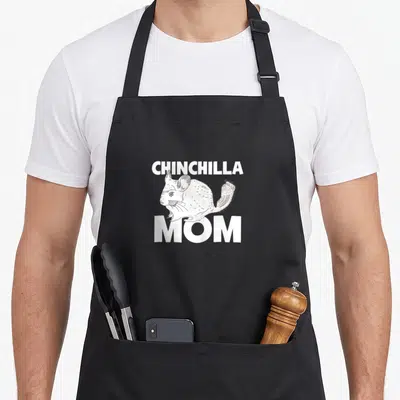 Funny chinchilla pet apron - White line-art chinchilla illustration between bold CHINCHILLA and MOM text labels — shown on a black cotton canvas apron against a white background