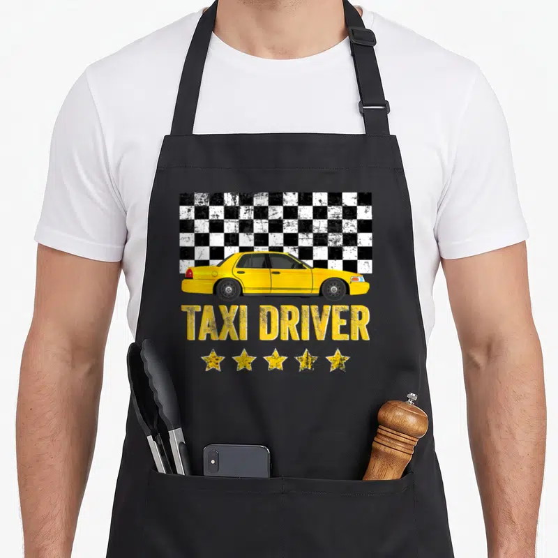 Cab taxi driver apron - Yellow taxi sedan over checkered background with TAXI DRIVER text and five stars — shown on a black cotton canvas apron against a white background