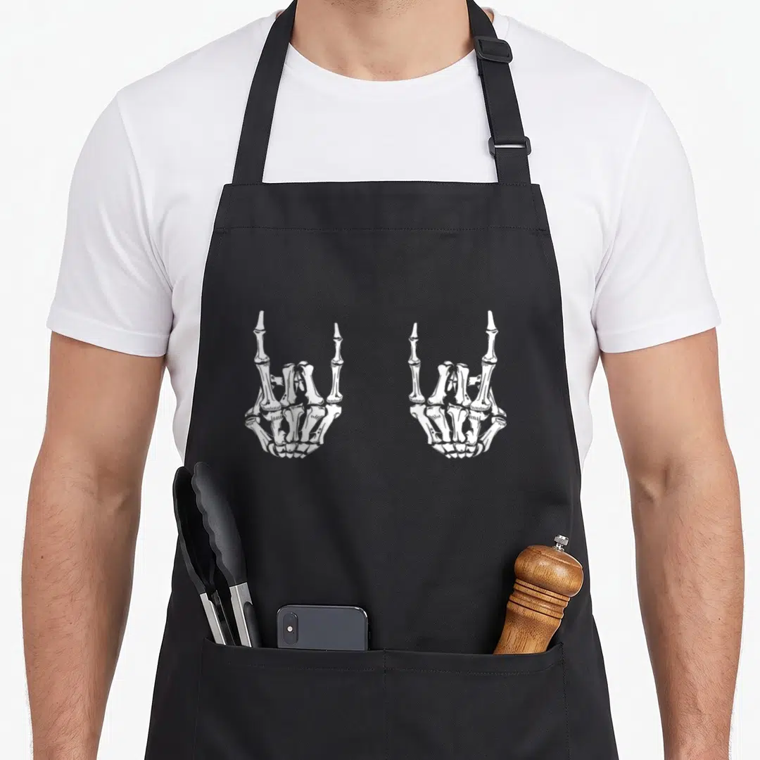 Star skeleton apron - Two white skeleton hands making rock on sign side by side — shown on a black cotton canvas apron against a white background