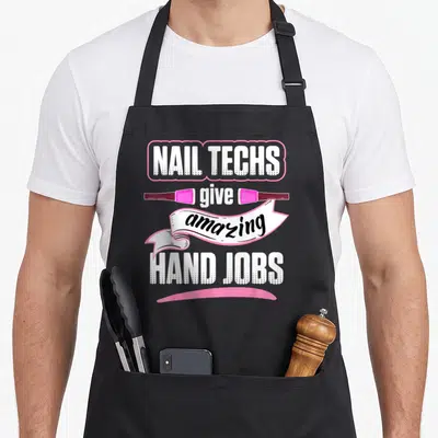 Hand manicurist apron - Stacked text nail techs give amazing hand jobs with two pink polish bottles and white ribbon — shown on a black cotton canvas apron against a white background