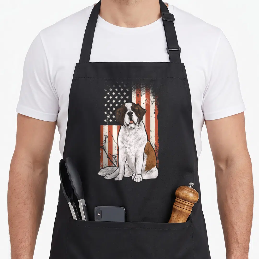 Bernard american flag apron - Seated Saint Bernard dog illustration overlaid on a distressed red white and blue USA flag — shown on a black cotton canvas apron against a white background