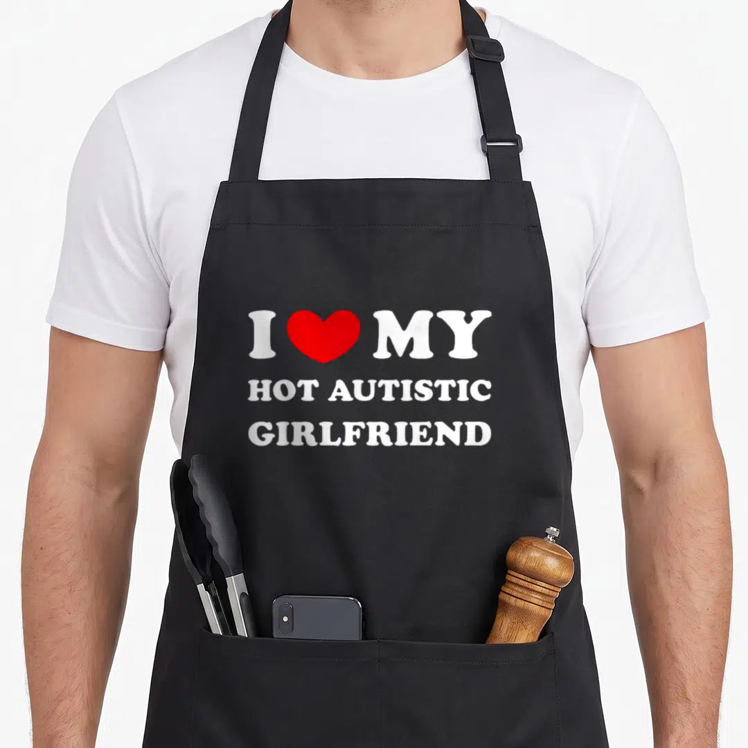 Autistic love hot apron - Red heart between I and MY white text reading HOT AUTISTIC GIRLFRIEND — shown on a black cotton canvas apron against a white background