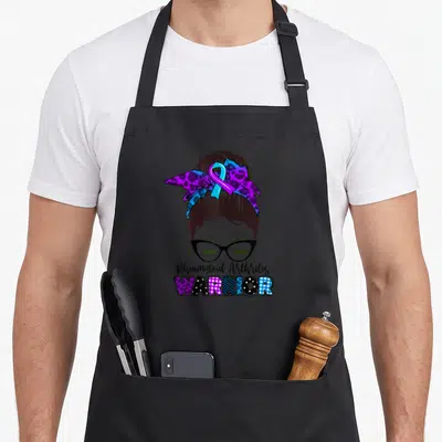 Ribbon messy aprons - Cartoon woman with glasses and purple blue patterned bow above stacked Rheumatoid Arthritis — shown on a black cotton canvas apron against a white background