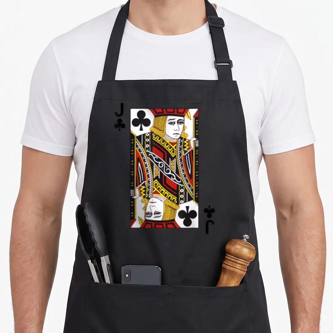 Blackjack j apron - Mirrored Jack of Clubs card with J and club symbols in red, yellow, white, and black — shown on a black cotton canvas apron against a white background