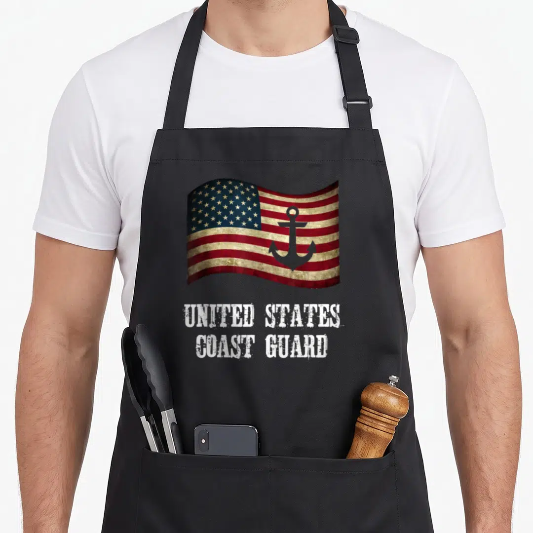 Guard coast apron - Distressed US flag with grey anchor and stacked UNITED STATES COAST GUARD text — shown on a black cotton canvas apron against a white background