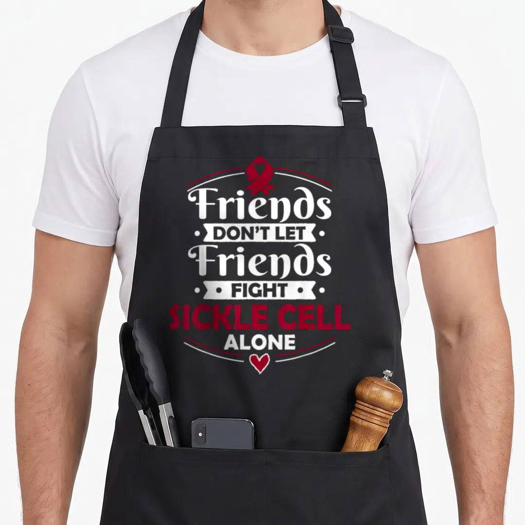 Scd sickle cell awareness apron - Red ribbon and text Friends Don't Let Friends Fight Sickle Cell Alone with heart — shown on a black cotton canvas apron against a white background