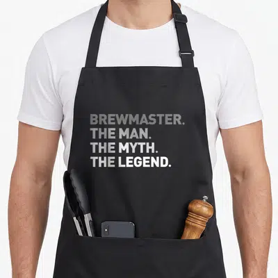 Brewmaster craft apron - Stacked white text reading BREW MASTER THE MAN THE MYTH THE LEGEND on grey background — shown on a black cotton canvas apron against a white background