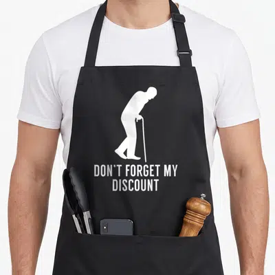 Forget discount apron - White elderly silhouette with cane and discount text on black bib — shown on a black cotton canvas apron against a white background