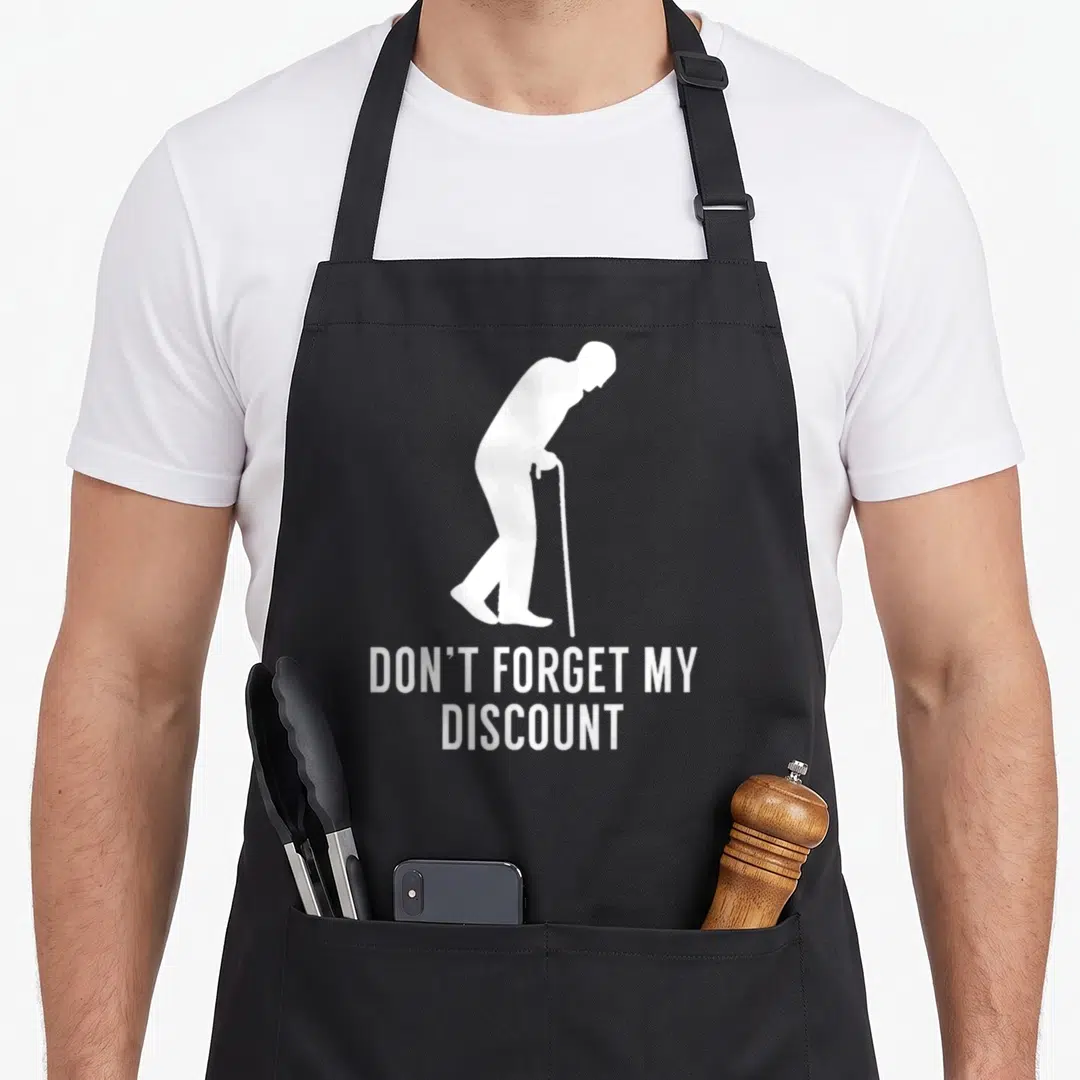 Forget discount apron - White elderly silhouette with cane and discount text on black bib — shown on a black cotton canvas apron against a white background