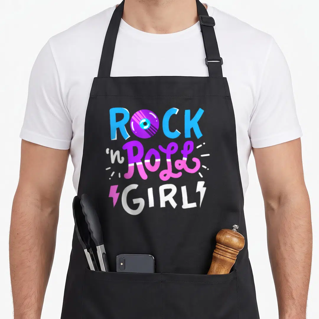 Music roll apron - Rock n Roll Girl text with vinyl record O and sparkle lines in blue purple pink and white — shown on a black cotton canvas apron against a white background