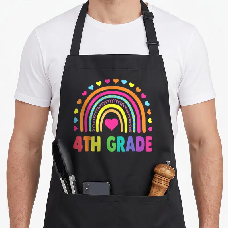 4th rainbow teacher apron - Rainbow arch with pink heart and colorful hearts above 4TH GRADE text — shown on a black cotton canvas apron against a white background