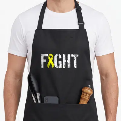Fight sarcoma ribbon apron - White distressed FIGHT text with a yellow awareness ribbon replacing the letter I — shown on a black cotton canvas apron against a white background