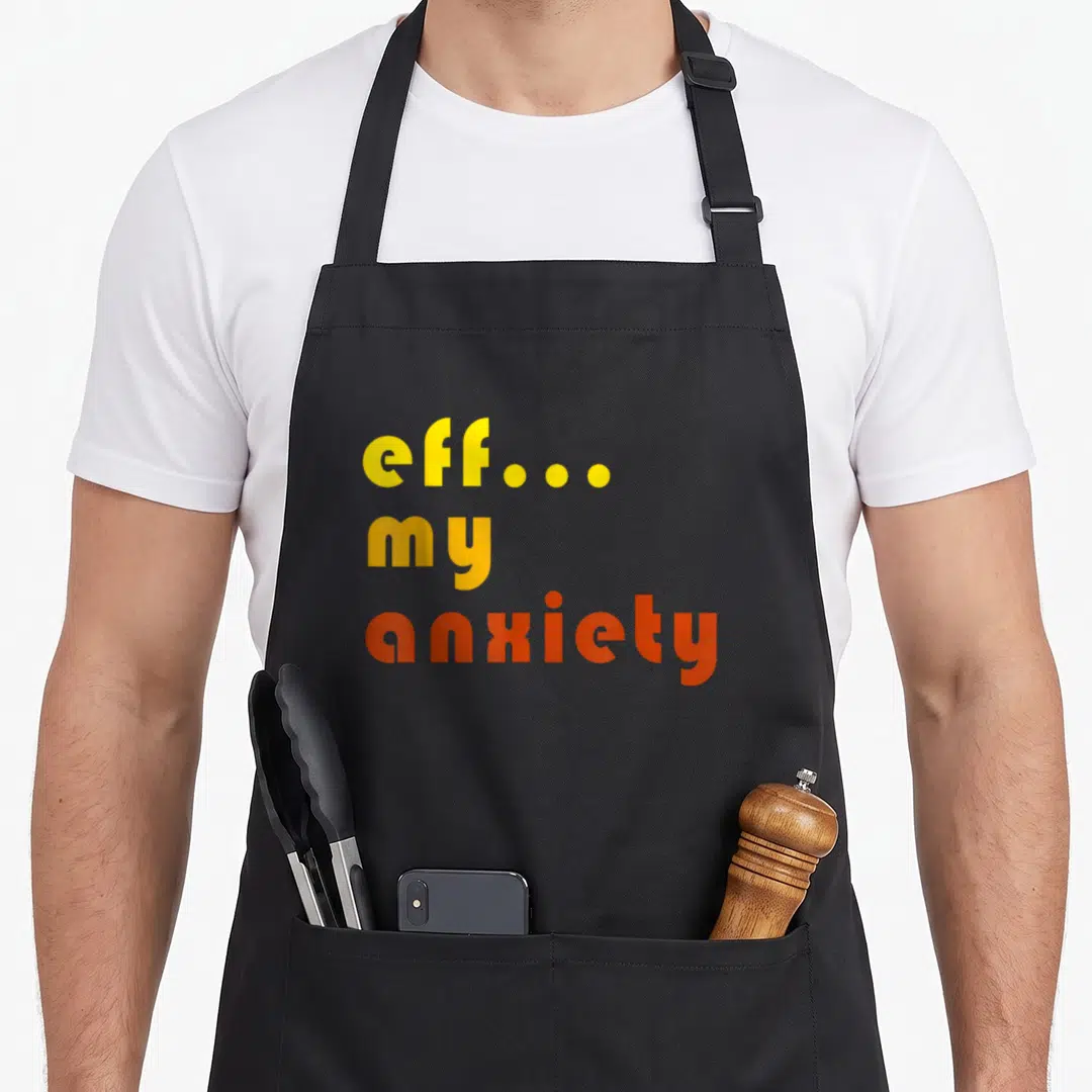 Eff anxiety awareness apron - Stacked eff my anxiety text in yellow and orange gradient font — shown on a black cotton canvas apron against a white background