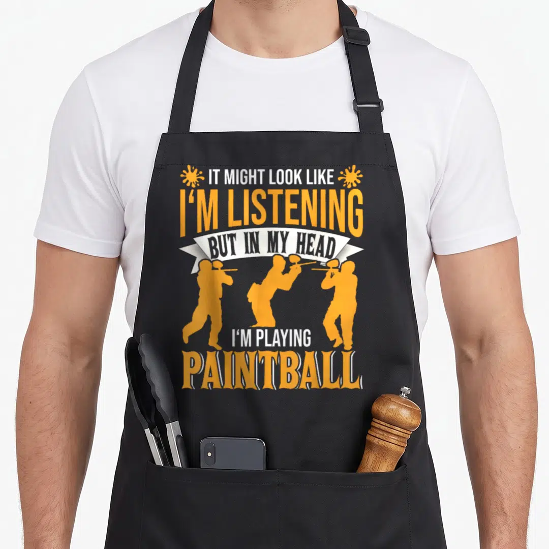 Funny paintball lover apron - Stacked orange and white text with three paintball player silhouettes and two splat — shown on a black cotton canvas apron against a white background