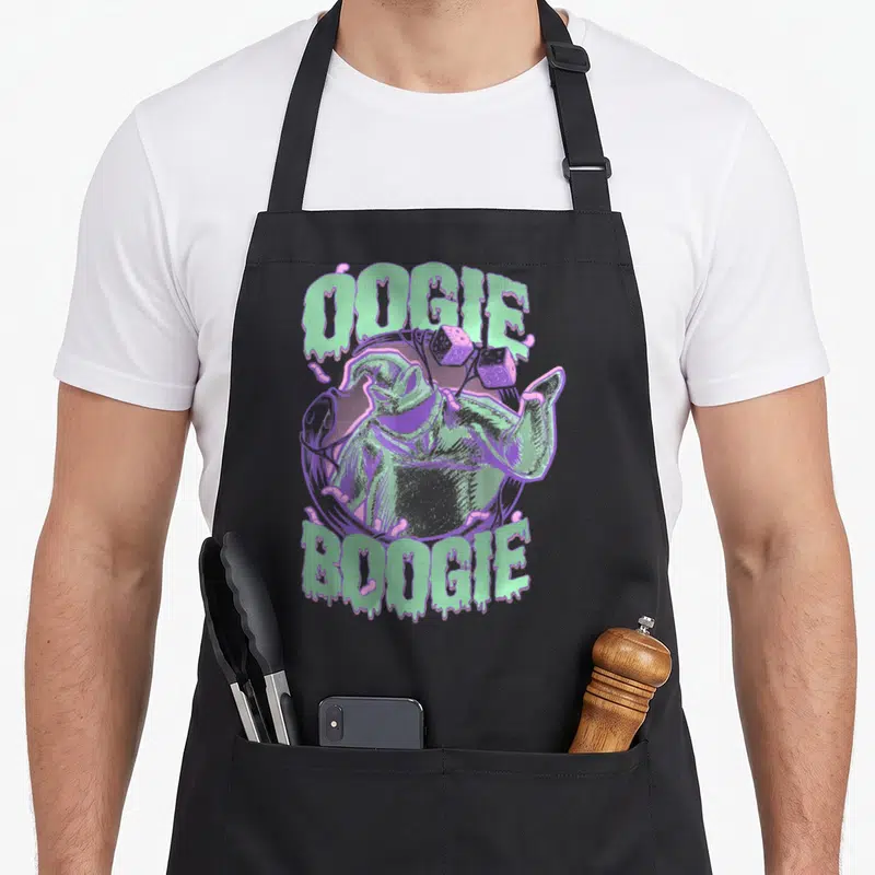 Boogie christmas apron - Oogie Boogie portrait with dice and dripping text in mint green and purple — shown on a black cotton canvas apron against a white background