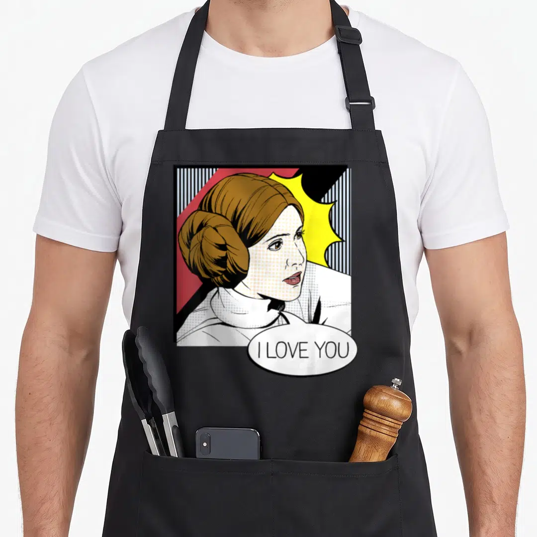 Leia couple apron - Retro Princess Leia portrait with I LOVE YOU speech bubble and striped background — shown on a black cotton canvas apron against a white background