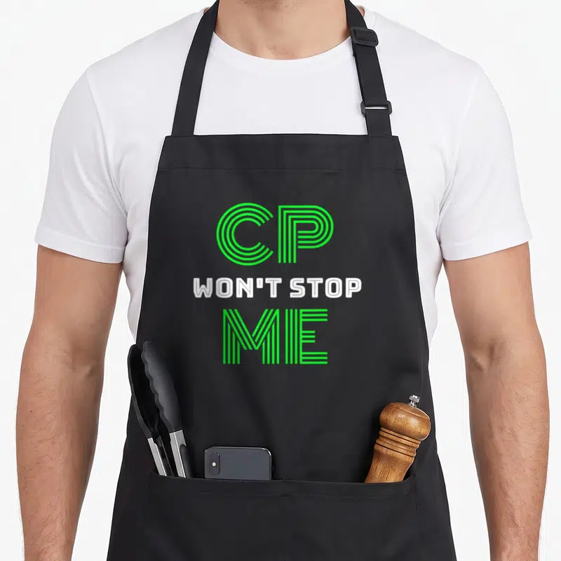 Damage ribbon mom apron - Stacked green and white text reading CP WON'T STOP ME in linear typography — shown on a black cotton canvas apron against a white background