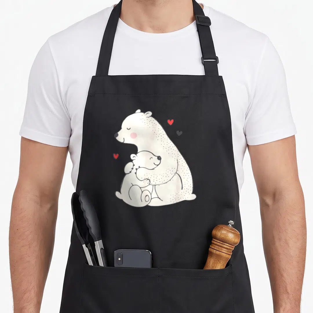 Unique mama bear apron - Cartoon polar bear hugging cub with three red and black hearts floating nearby — shown on a black cotton canvas apron against a white background