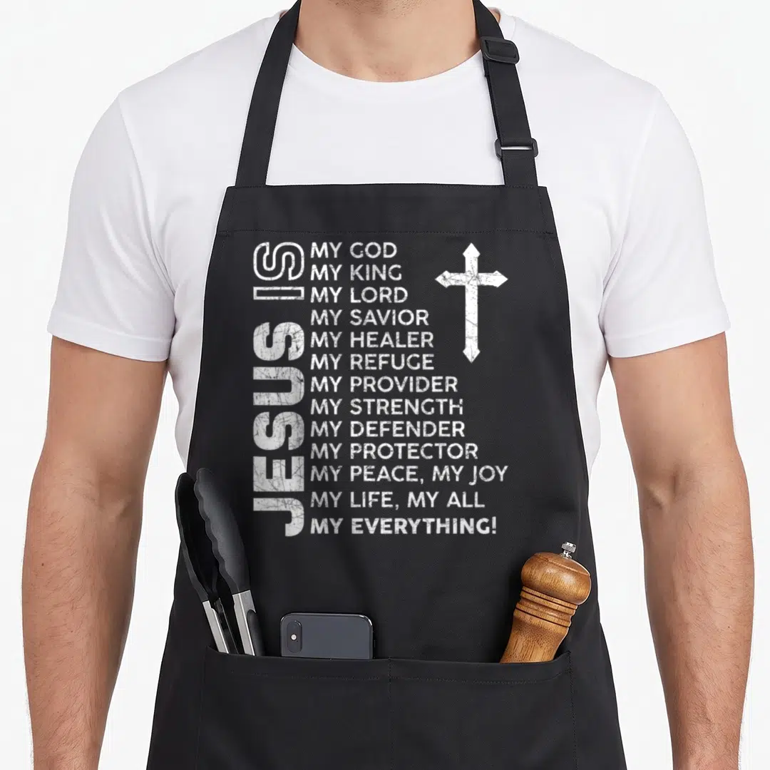 Cool jesus christian apron - Vertical JESUS text, stacked divine titles, and distressed white cross — shown on a black cotton canvas apron against a white background