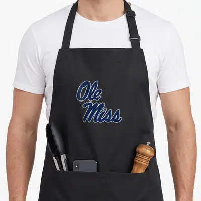 Ole mississippi apron - Stacked navy blue cursive Ole Miss text with white outline on canvas — shown on a black cotton canvas apron against a white background