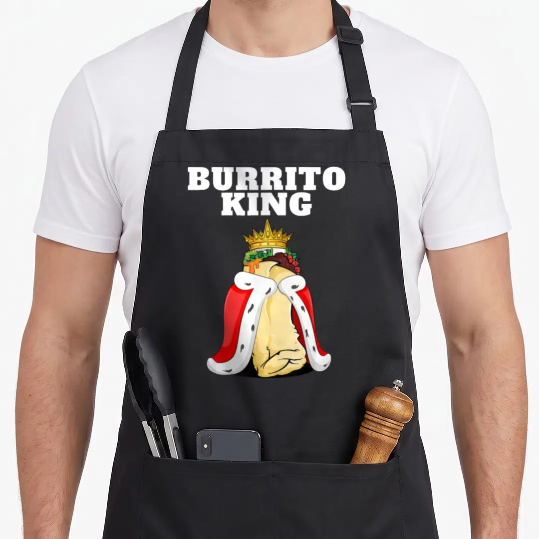 King mexican apron - Cartoon burrito wearing gold crown and red cape under white BURRITO KING text — shown on a black cotton canvas apron against a white background