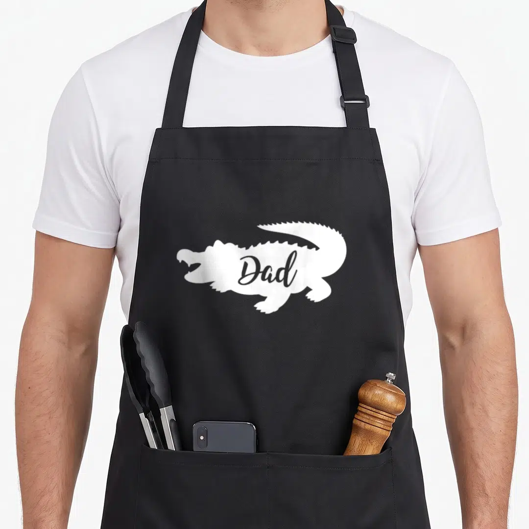 School gatorade apron - White alligator silhouette with Dad text inside on black background — shown on a black cotton canvas apron against a white background
