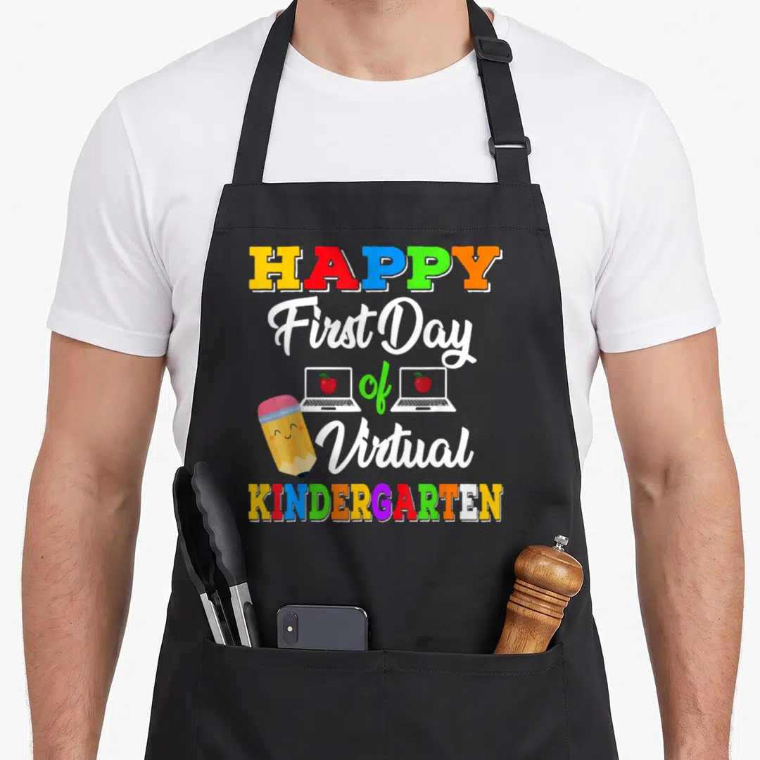 Virtual teaching apron - Stacked text HAPPY First Day of Virtual KINDERGARTEN with cartoon pencil and two laptops — shown on a black cotton canvas apron against a white background