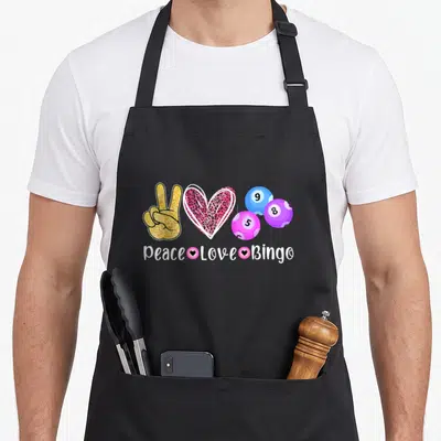 Peace bingo apron - Gold peace hand, leopard heart, three colored bingo balls, and white text reading Peace Love Bingo — shown on a black cotton canvas apron against a white background