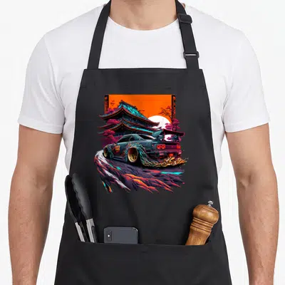 Japanese racing car apron - Drifting sports car with fire, pagoda, orange sky, purple trees, retro art — shown on a black cotton canvas apron against a white background
