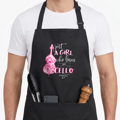 Cellist orchestra cello apron - Pink floral cello illustration beside stacked white text reading just a girl who loves — shown on a black cotton canvas apron against a white background