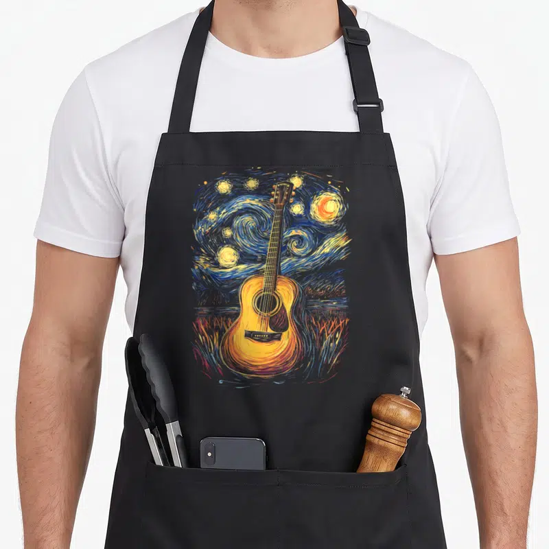 Inspired starry night apron - Watercolor acoustic guitar centered on swirling blue and yellow starry night sky — shown on a black cotton canvas apron against a white background