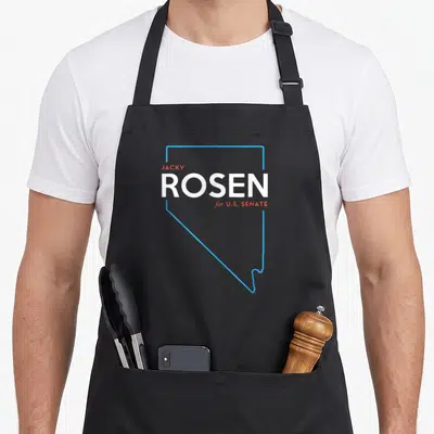 Jacky nevada boy apron - Blue Nevada outline with red and white text reading Jacky Rosen for U.S. Senate — shown on a black cotton canvas apron against a white background