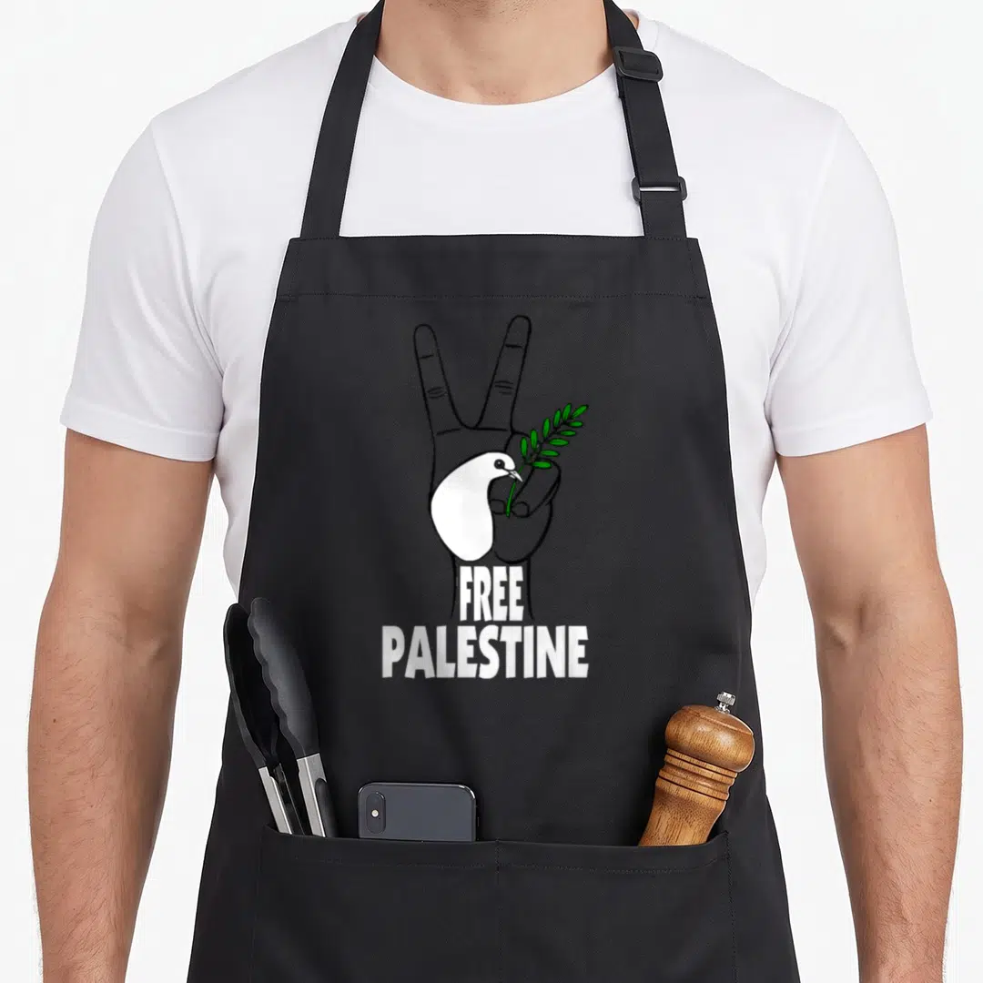 West palestine apron - Hand peace sign holding white dove and green olive branch with stacked text — shown on a black cotton canvas apron against a white background