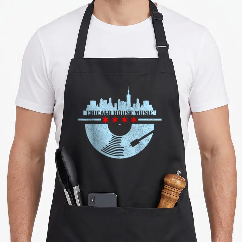 Chicago vinyl apron - Light blue skyline, red stars, vinyl record, and CHICAGO HOUSE MUSIC text — shown on a black cotton canvas apron against a white background