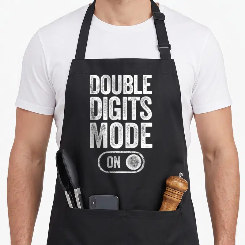 Digit mode birthday apron - White DOUBLE DIGITS MODE ON text and toggle switch on black bib — shown on a black cotton canvas apron against a white background