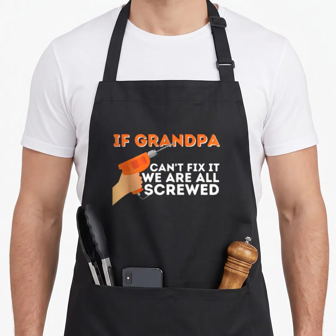 Granddad grandpa apron - Orange drill and text If Grandpa Can't Fix It We Are All Screwed — shown on a black cotton canvas apron against a white background
