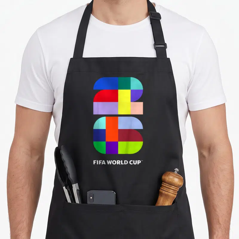 Fifa soccer birthday apron - Multicolored geometric 2026 logo above white FIFA WORLD CUP text — shown on a black cotton canvas apron against a white background