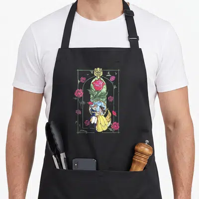 Belle stained apron - Stained glass Belle Beast embrace red rose yellow lion green frame line art — shown on a black cotton canvas apron against a white background