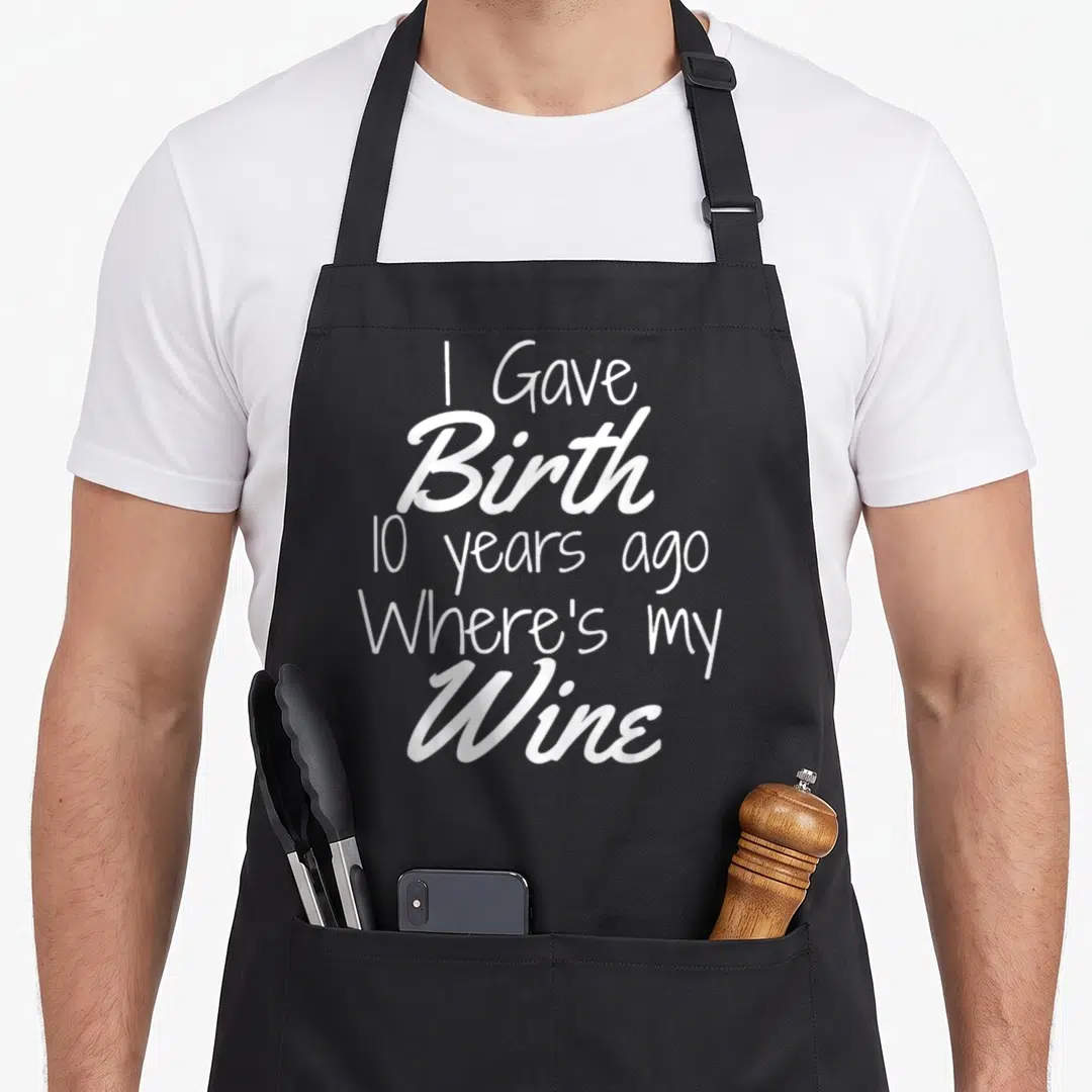 Birthday wine aprons - White text I Gave Birth 10 years ago Where's my Wine on black fabric — shown on a black cotton canvas apron against a white background