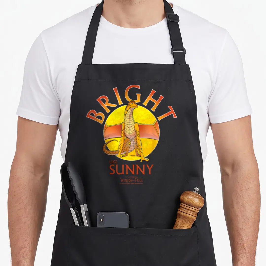 Wing fire girl apron - BRIGHT LIKE SUNNY text with yellow circle and orange cartoon dragon — shown on a black cotton canvas apron against a white background
