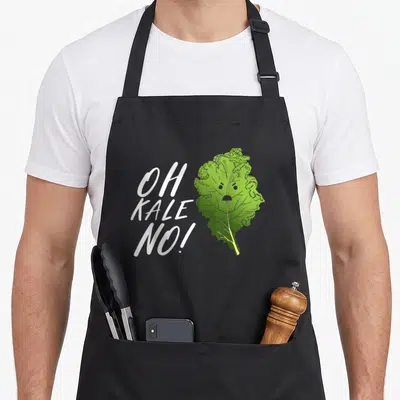 Kale vegetarian vegan apron - White Oh Kale No text next to sad cartoon green kale leaf with face — shown on a black cotton canvas apron against a white background