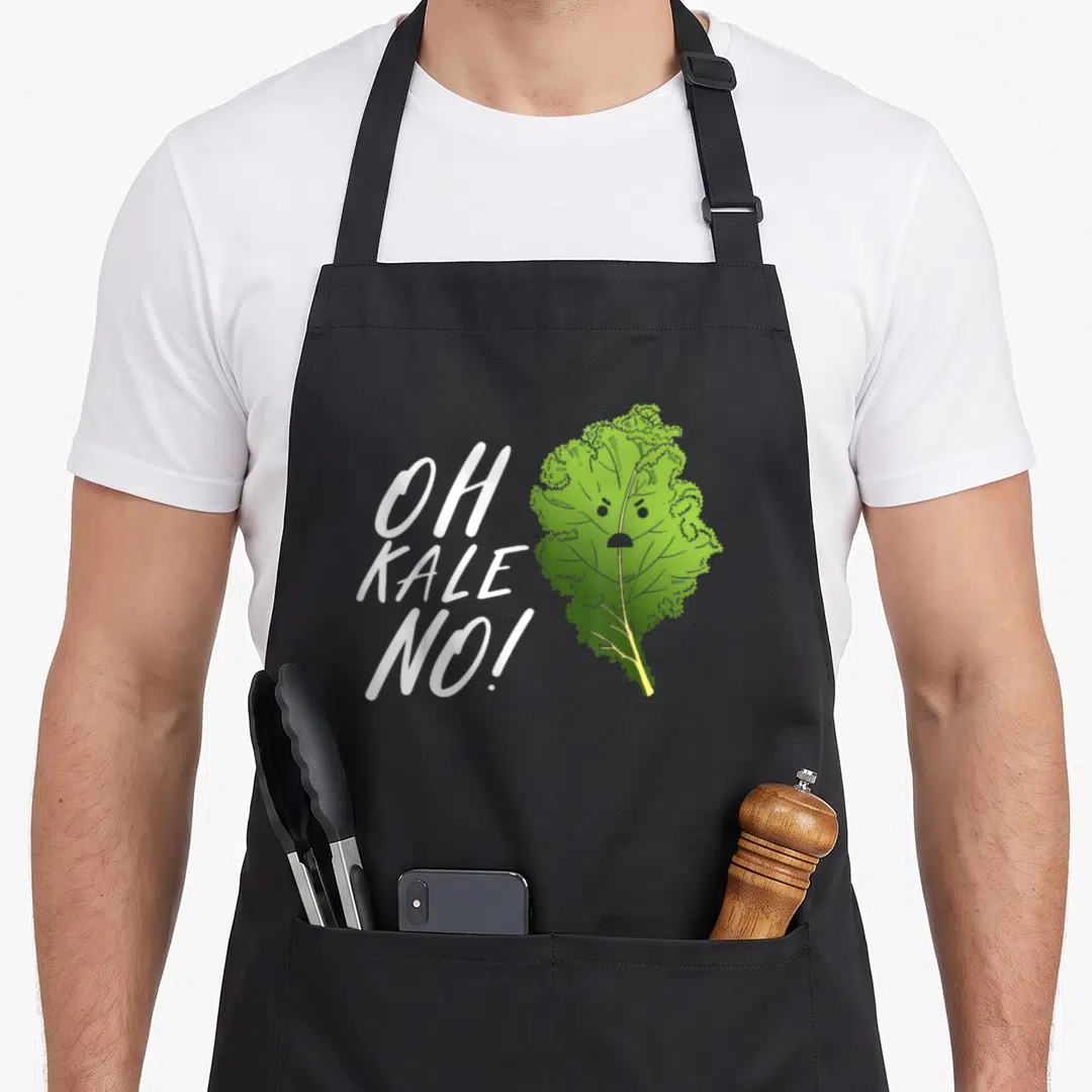 Kale vegetarian vegan apron - White Oh Kale No text next to sad cartoon green kale leaf with face — shown on a black cotton canvas apron against a white background